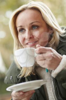 Woman In Outdoor Caf With Hot Drink  Wearing Winter Clothes