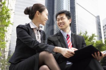 Chinese Businessman And Businesswoman Talking Outside Office