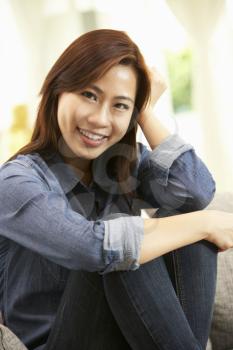 Young Chinese Woman  Relaxing On Sofa At Home