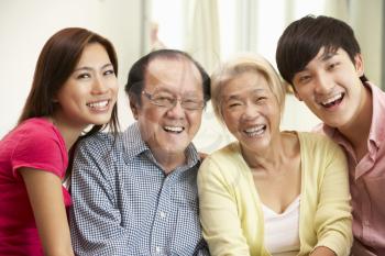 Portrait Of Chinese Parents With Adult Children Relaxing At Home Together