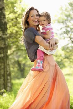 Mother Carrying Young Daughter Through Summer Field