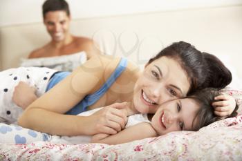Family Relaxing In Bed Together