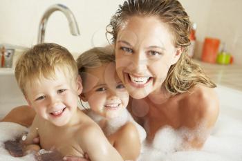 Mother With Children Relaxing In Bubble Filled Bath