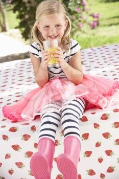 Young Girl Wearing Pink Wellington Boots Drinking Orange Juice