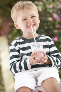 Young Boy Wearing Wellington Boots Drinking Milkshake