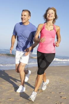 Senior Couple Exercising On Beach