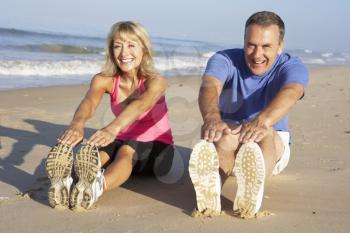 Senior Couple Exercising On Beach