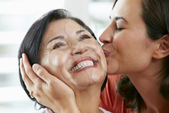 Portrait Of Adult Daughter Kissing Mother