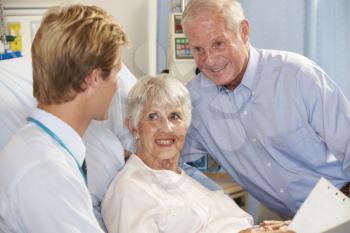 Doctor Talking To Senior Couple On Ward