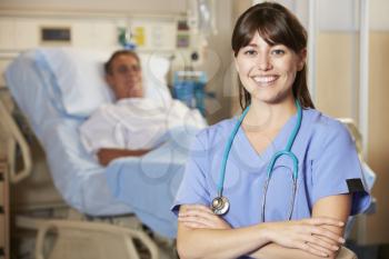 Portrait Of Nurse With Patient In Background