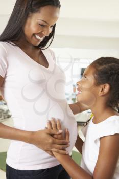 Daughter Listening To Pregnant Mother's Stomach