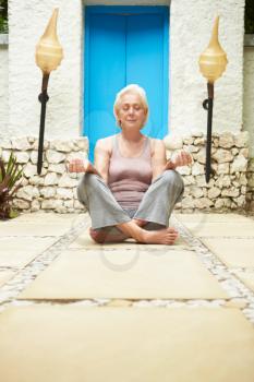Senior Woman Meditating Outdoors At Health Spa