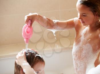 Two Girls Sharing Bubble Bath And Washing Hair