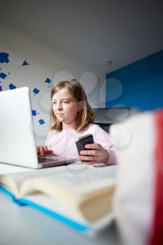 Girl Using Mobile Phone Instead Of Studying In Bedroom