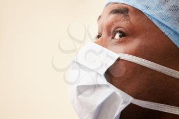 Surgeon In Operating Theatre Wearing Scrubs And Mask