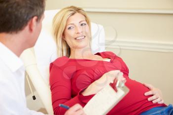 Pregnant Woman Being Given Ante Natal Check By Doctor