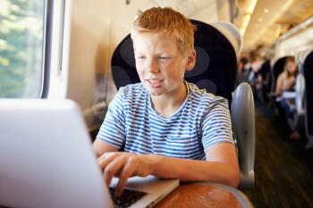 Boy Using Laptop On Train Journey