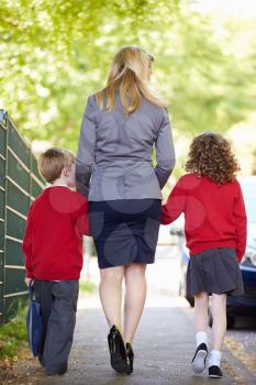 Mother Walking To School With Children On Way To Work