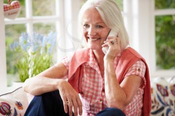 Middle Aged Woman At Home Talking On Phone