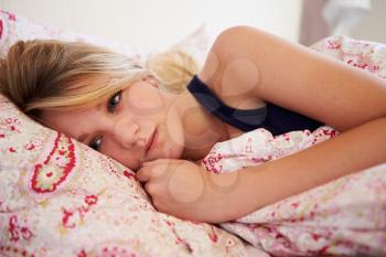 Worried Teenage Girl Lying In Bed
