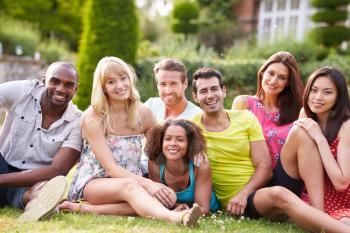 Group Of Friends Sitting On Grass Together