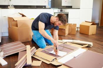 Man Putting Together Self Assembly Furniture In New Home