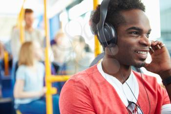 Man Wearing Headphones Listening To Music On Bus Journey