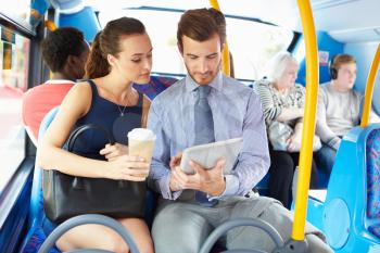 Businessman And Woman Using Digital Tablet On Bus