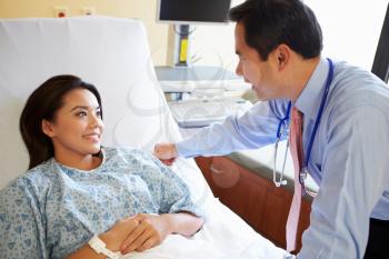 Doctor Talking To Female Patient On Ward