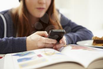 Teenage Girl Sending Text Message Whilst Studying