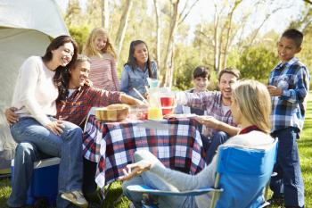 Two Families Enjoying Camping Holiday In Countryside