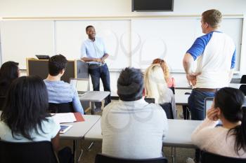 Male Tutor Teaching University Students In Classroom