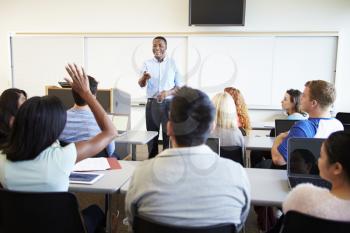 Male Tutor Teaching University Students In Classroom