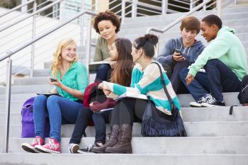 Group Of High School Students Sitting Outside Building