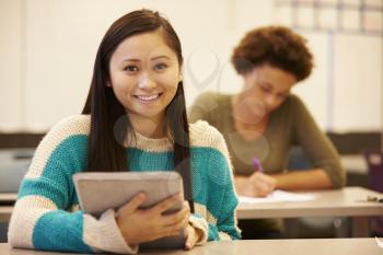 High School Student At Desk In Class Using Digital Tablet