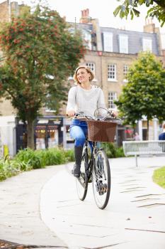Young Woman Cycling Through Urban Park