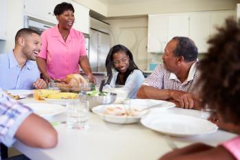 Multi-Generation Family Sitting Around Table Eating Meal