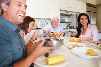 Multi-Generation Family Sitting Around Table Eating Meal