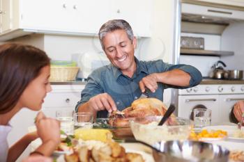 Multi-Generation Family Sitting Around Table Eating Meal