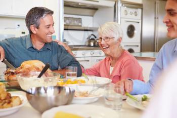 Multi-Generation Family Sitting Around Table Eating Meal