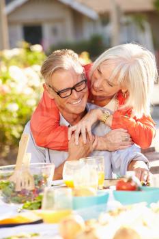 Mature Romantic Couple Enjoying Outdoor Meal In Garden