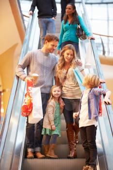 Family On Escalator In Shopping Mall Together