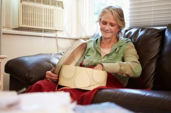 Senior Woman Keeping Warm Under Blanket With Memory Box