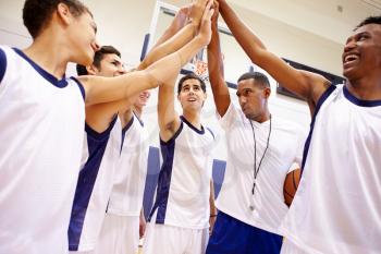 Male High School Basketball Team Having Team Talk With Coach