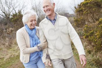 Senior Couple Walking Through Winter Countryside