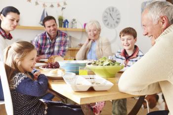 Multi Generation Family Eating Lunch At Kitchen Table