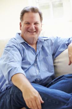 Portrait Of Overweight Man Sitting On Sofa