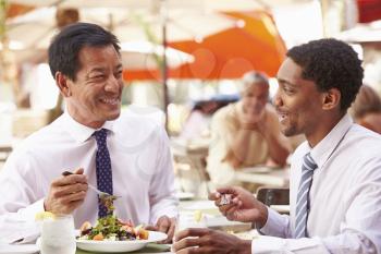 Two Businessmen Having Meeting In Outdoor Restaurant