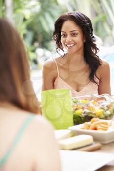 Two Female Friends Enjoying Meal Outdoors At Home