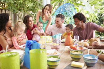 Group Of Families Celebrating Child's Birthday At Home